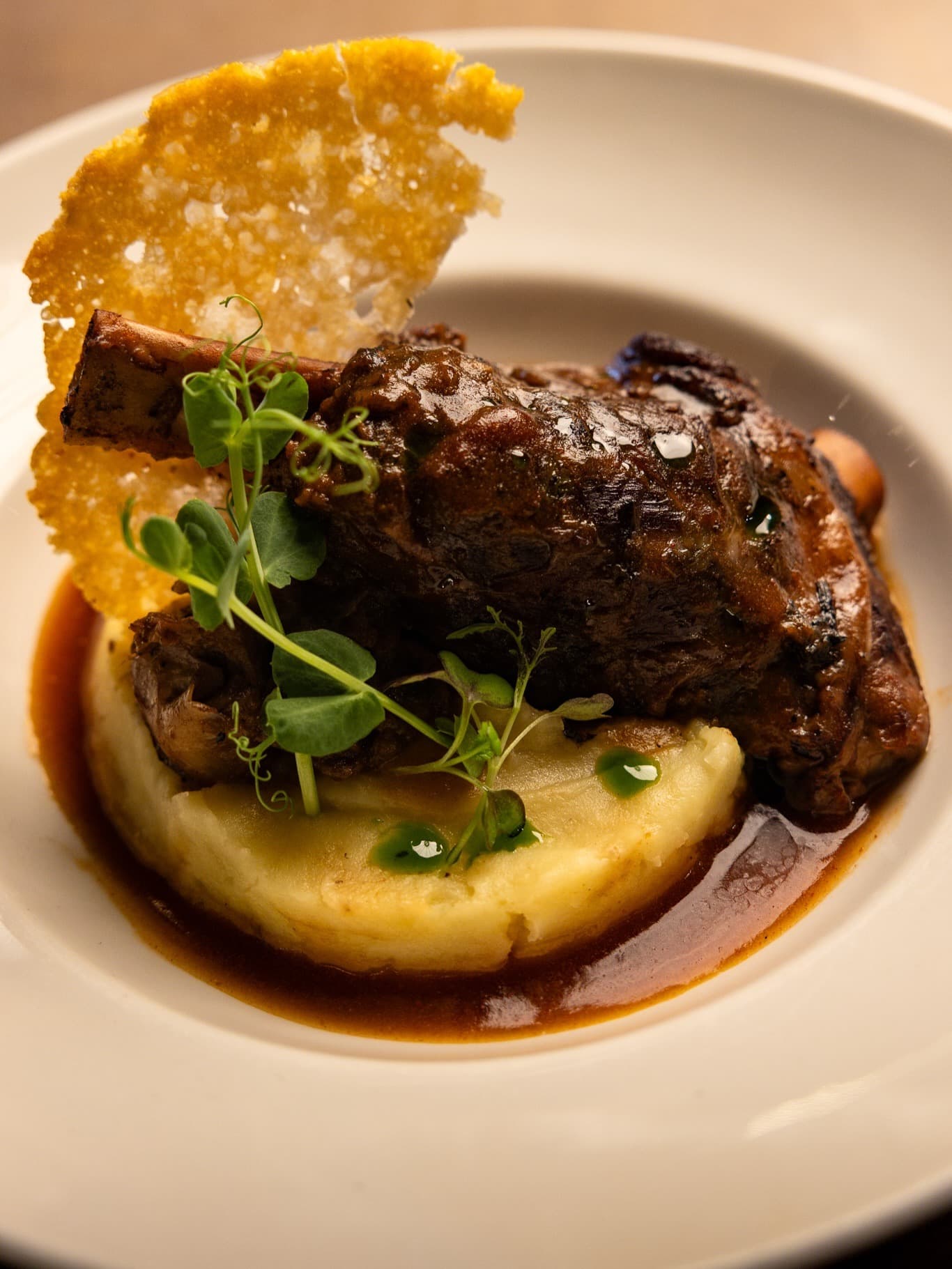 Slow-roasted lamb shank with purée and Parmesan wafer